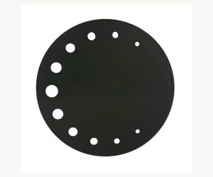 Das Bild zeigt eine runde, schwarze Topplatte des Filou2 Kachelofens. Die Platte hat mehrere dekorative, unterschiedlich große Löcher entlang eines Kreisbogens nahe des Randes. Diese Ersatzteilkomponente ist aus robustem Material gefertigt und kann zur optischen Aufwertung sowie zur Funktionalität des Kaminofens beitragen. Ideal, um den Look Ihres Holzofens anzupassen.