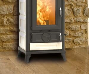 Beige Sofia Evo-brændeovn med synlige flammer foran en rustik stenvæg på et trægulv.