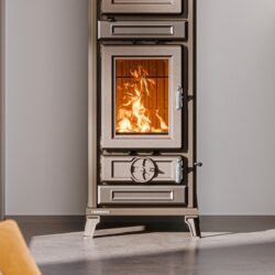 Komfur med brændende ild bag glas, nærbillede af glasset og betjeningselementerne foran.