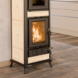 Beige kachel met brandend vuur, rechthoekige glazen voorkant, moderne keuken op de achtergrond.