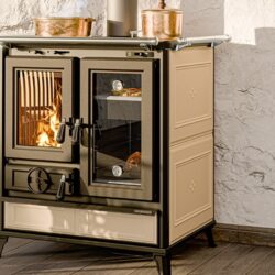 Fornuis met oven, crèmekleurig, vlam van brandhout zichtbaar, op rustieke muur, koperen potten op het fornuis.