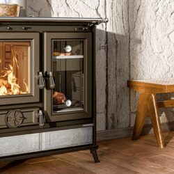 Een traditionele houtkachel met een kijkvenster. Er brandt een vuur in de kachel en er is een thermometer zichtbaar.