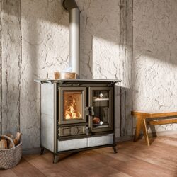 Compacte houtkachel met houtcompartimenten, brandend vuur binnen, in een rustieke kamer met houten vloer en bank.