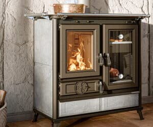 Komfur med brændende ild bag glasrude, venstre fokus. Komfur med termometer og steg til højre.