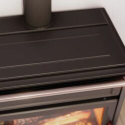 Close-up of a "Scrigno Agora" stove: detail of the stove with black surface and visible fire inside.