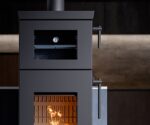 Modern stove with a focus on details: visible door handles, thermometer and blazing fire in a dark gray housing.