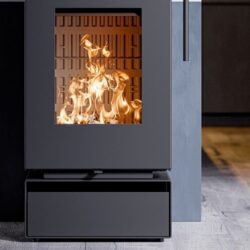 Modern wood-burning stove with visible flames, focusing on the rectangular glass front. Elegant, dark design.