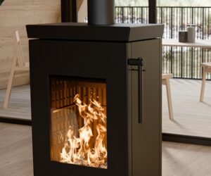 Modern wood-burning stove in a room with wood paneling. Detailed view shows the play of flames behind a glass front.
